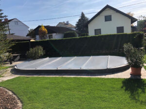 Mittelgraue Poolabdeckung für individuell geformte Pools – Hochwertige, wetterbeständige und kindersichere Abdeckung für maßgefertigte Poolformen im Garten.