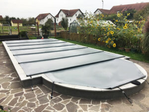 Maßgeschneiderte Poolabdeckung in Hellgrau für Pools mit runder Treppe – Hochwertige, kindersichere und witterungsbeständige Abdeckung für Pools mit abgerundetem Einstieg.