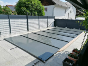 Hochwertige dunkelgraue Poolabdeckung schützt den Pool vor Verschmutzung und reduziert Wärmeverlust.