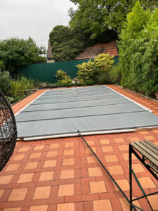 Wetterfeste mittelgraue Poolabdeckung schützt den Pool vor Schmutz, reduziert Wasserverdunstung und erhält die Wassertemperatur.