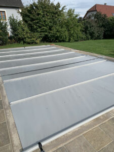 Mittelgraue Poolabdeckung mit Aluminiumverstärkung für optimalen Schutz und Energieeffizienz.