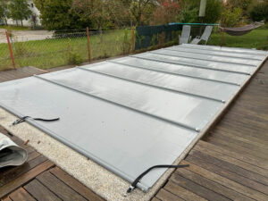 Pool mit mittelgrauer Stangenabdeckung – effektiver Schutz vor Verschmutzung, Verdunstung und Wärmeverlust.