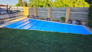 Hellblaue Poolabdeckung als Sonderform – maßgefertigter Schutz gegen Schmutz, Verdunstung und Energieverlust.