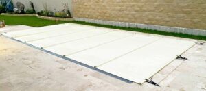 Sandfarbene Poolabdeckung mit Stangen – stilvolle Abdeckung für optimalen Schutz vor Schmutz und Verdunstung.