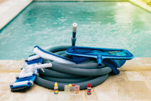 Poolreinigungsset mit Bodensauger, Bürste, Kescher und Wassertest-Kit zur effektiven Entfernung von Ablagerungen am Poolboden.