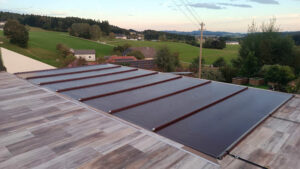 Dunkelbraune Poolabdeckung auf einer stilvollen Terrasse mit Holzoptik, umgeben von einer idyllischen Landschaft bei Sonnenuntergang.