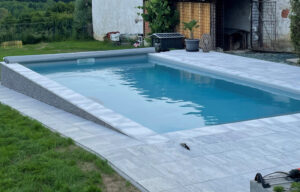 Mittelgraue Stangenabdeckung für Pool mit Querstreben aus Aluminium in modernem Garten.